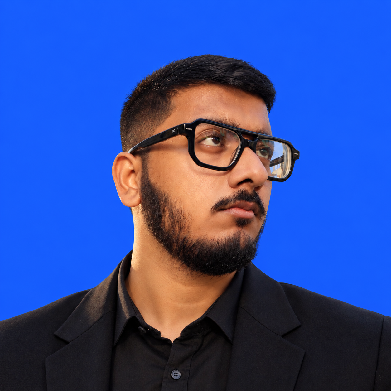 Samad Pathan, founder and creative director of Vereor, in a black blazer against a cobalt blue background